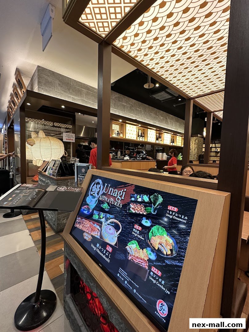 Interior view of Aburi-EN Nex restaurant showcasing a digital menu with Unagi dishes.