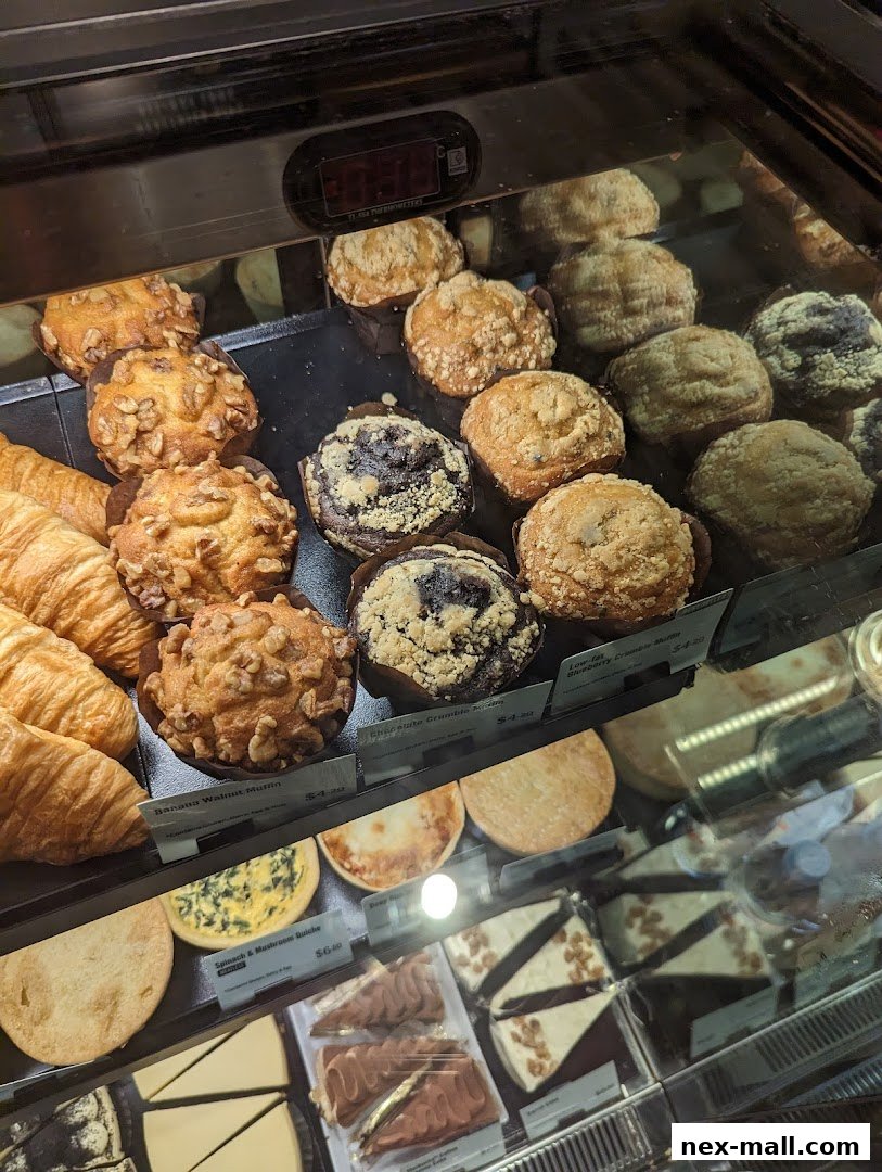 A display case filled with various pastries, muffins, quiches, and cakes at Starbucks.