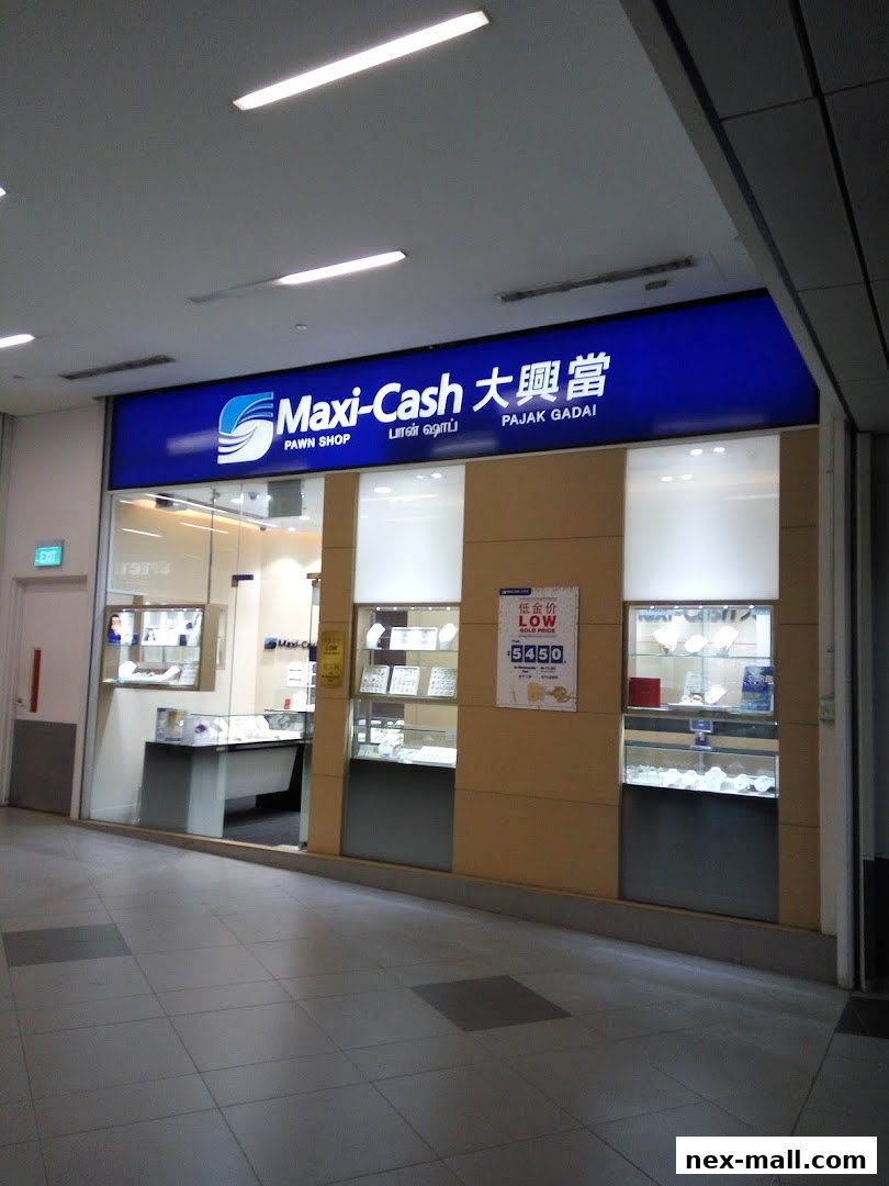 The exterior of a Maxi-Cash pawn shop with illuminated displays of jewelry and a promotional sign.
