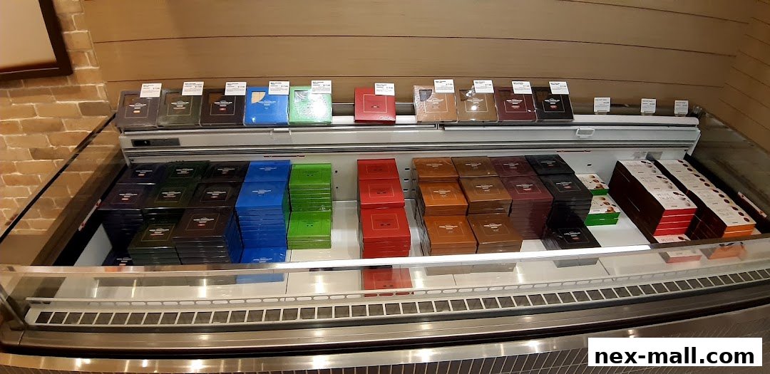A refrigerated display case filled with colorful boxes of Royce chocolates.