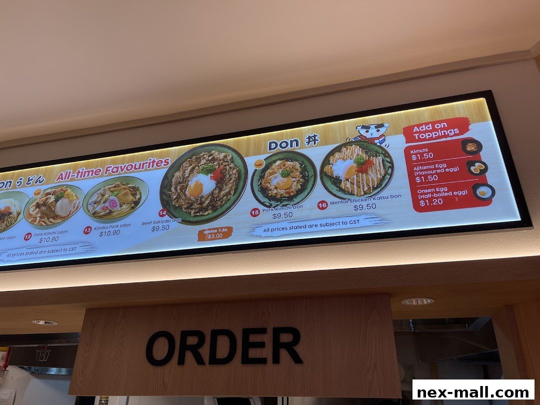 A brightly lit menu board showcasing various udon and donburi dishes with prices and toppings.