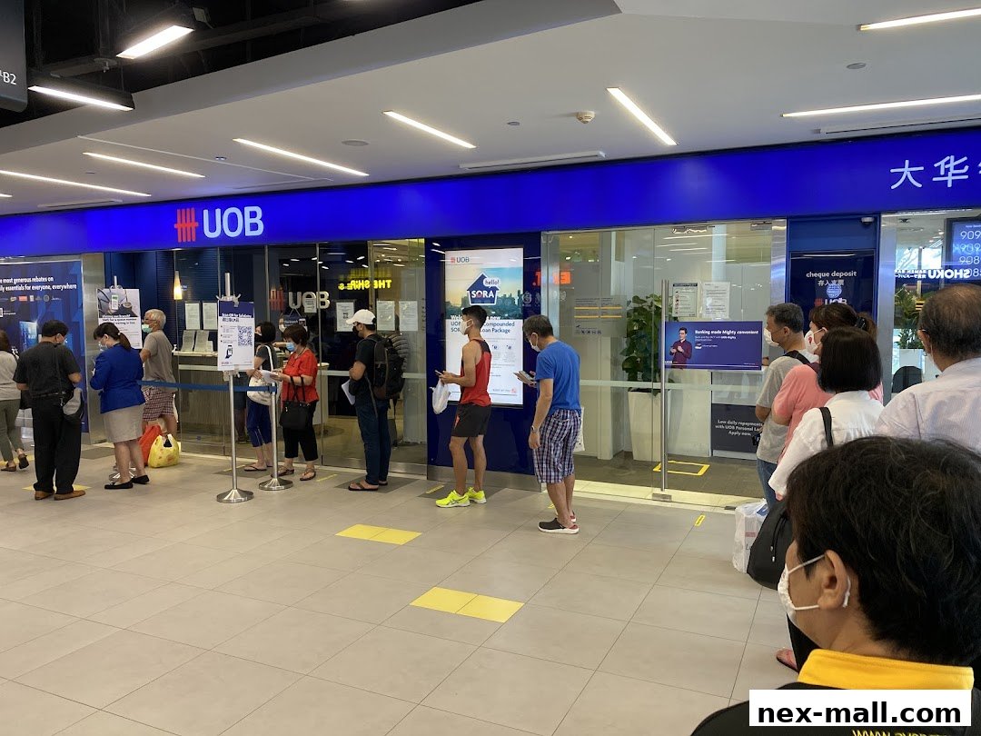 People queuing inside a UOB bank branch with clear signage and service counters visible.