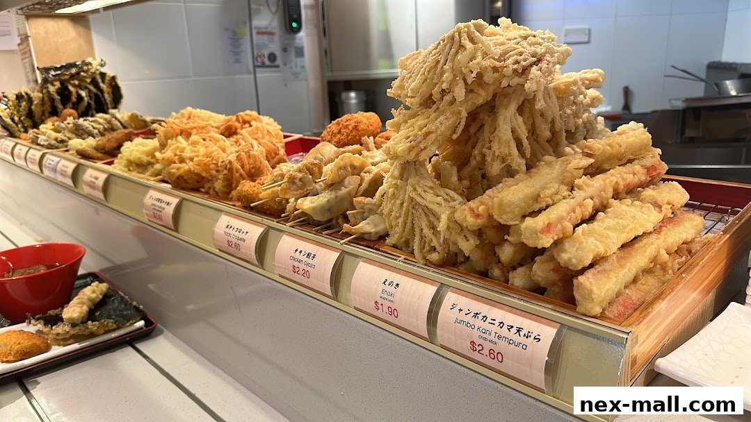 A display of various fried Japanese food items, including tempura and gyoza, with price labels.