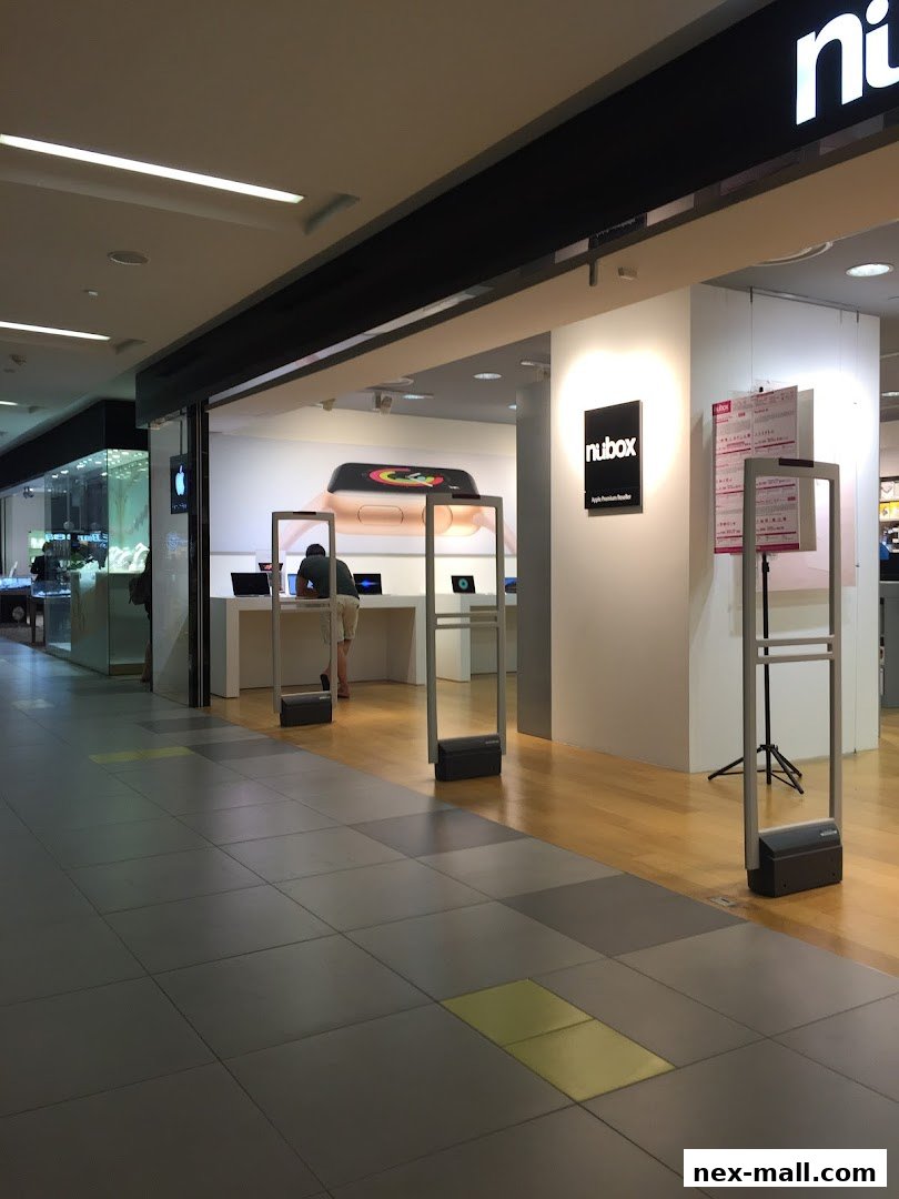 The entrance to an iStudio NEX shop, showcasing Apple products and a "nubox" sign.