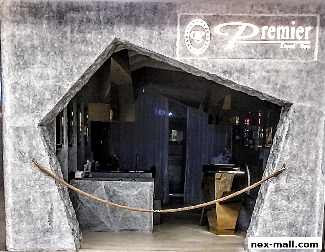 The entrance to Premier Dead Sea NEX, featuring a unique stone-like facade and a rope barrier.