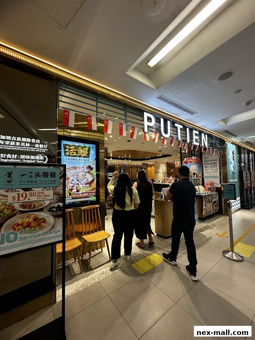 The entrance of PUTIEN NEX restaurant with people queuing and promotional displays.