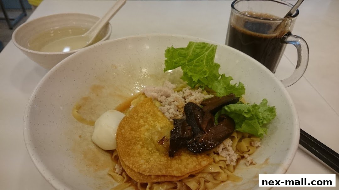 A bowl of noodles with minced meat, mushrooms, and a fried wonton, served with a side of soup and coffee.