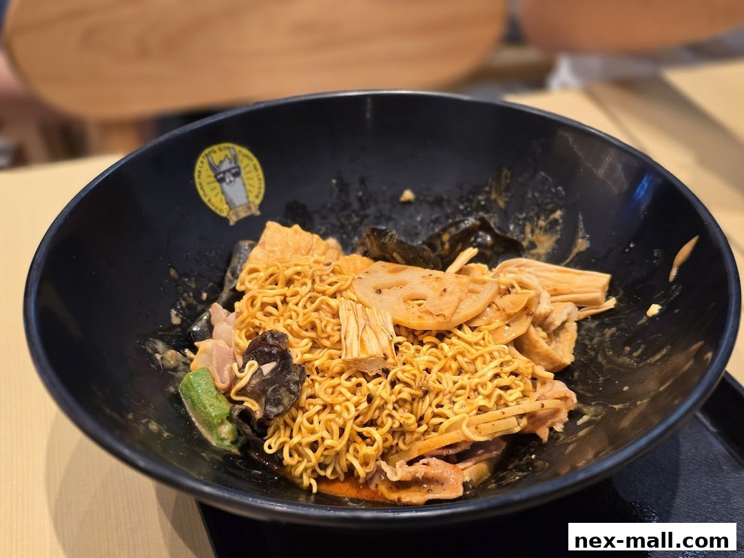 A black bowl filled with spicy mala tang noodles and various ingredients.