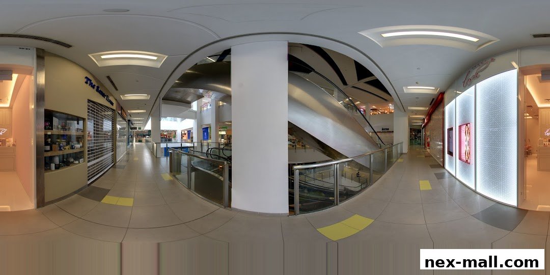A panoramic view of a shopping mall corridor with several shops, including Perky Lash.