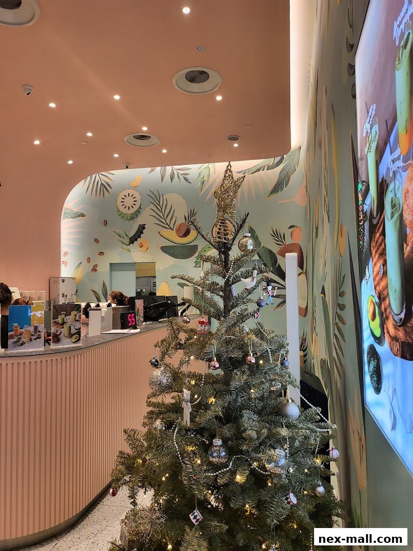 A festive Christmas tree stands inside a brightly lit shop with tropical-themed decor.