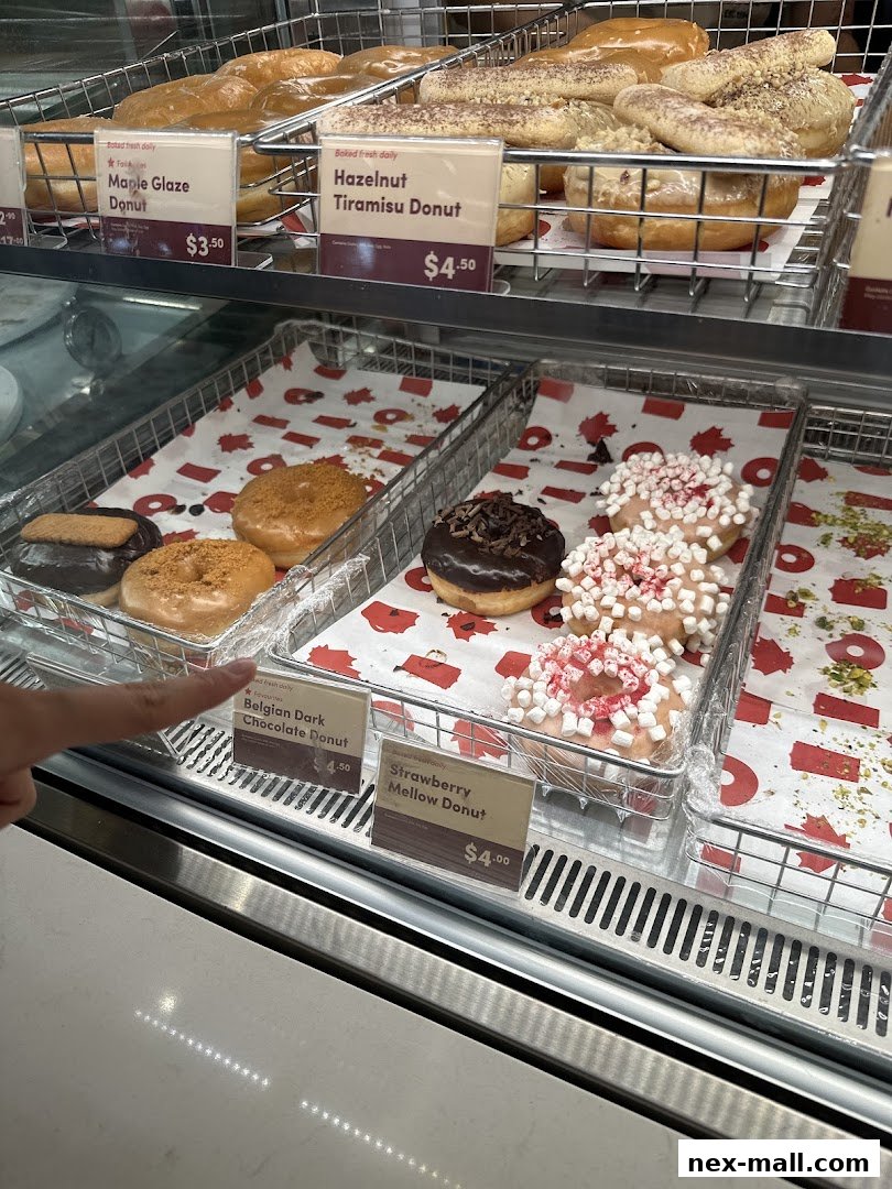 A display case filled with various freshly baked donuts at Tim Hortons.