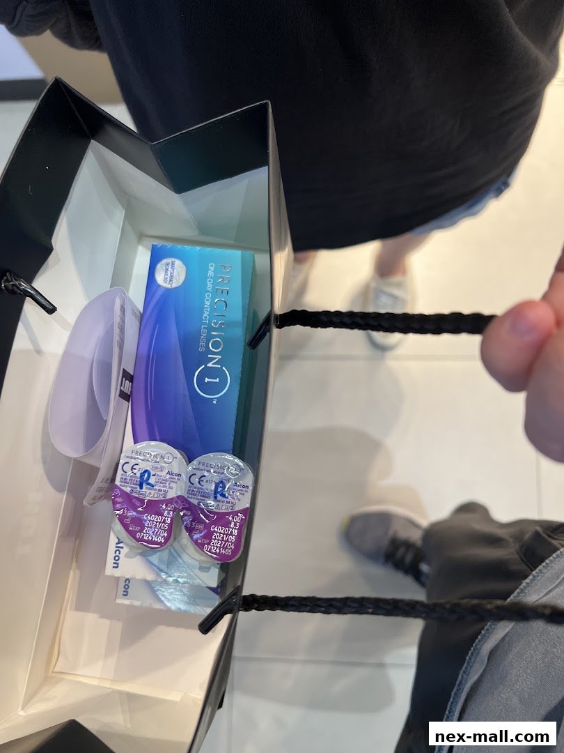 A shopping bag containing Precision 1 one-day contact lenses from Spectacle Hut.