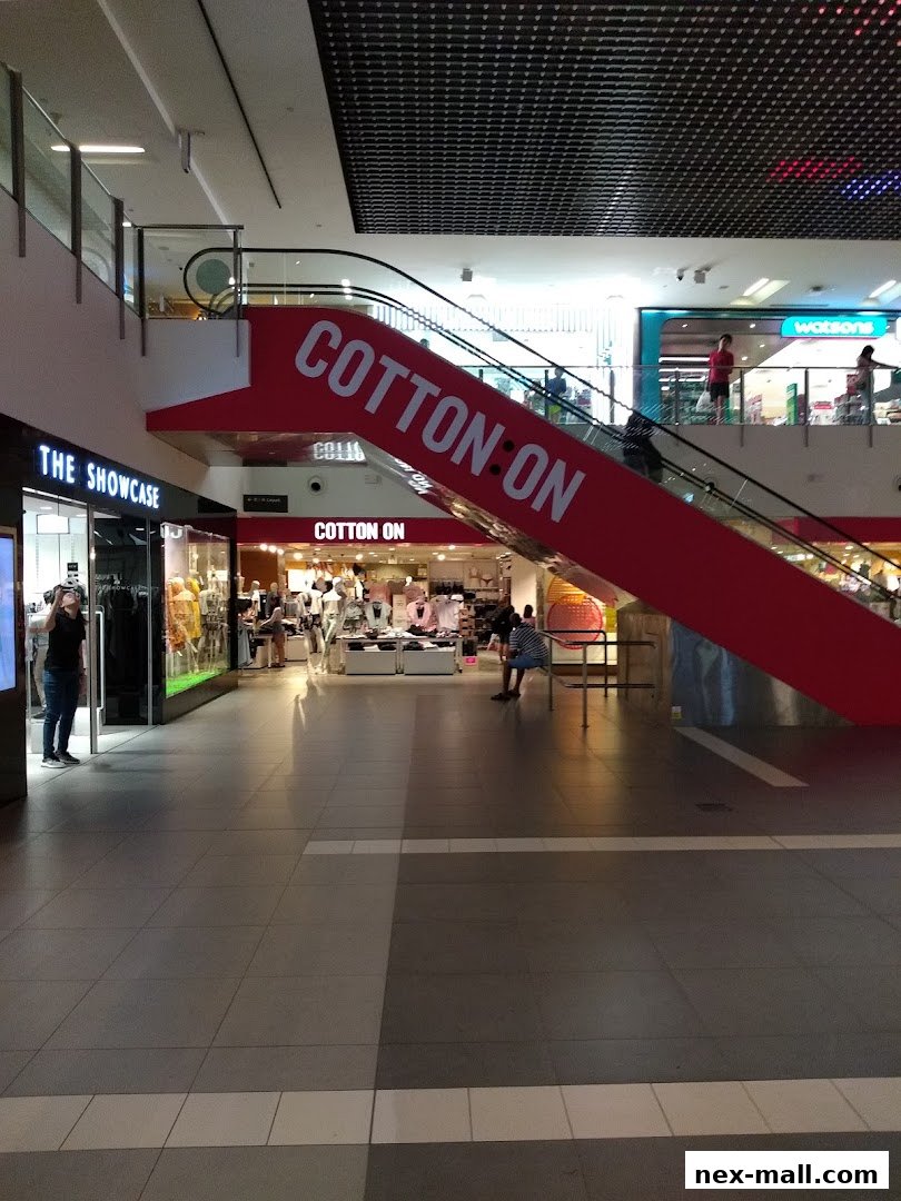 A shopping mall interior with a prominent Cotton On store and escalator.