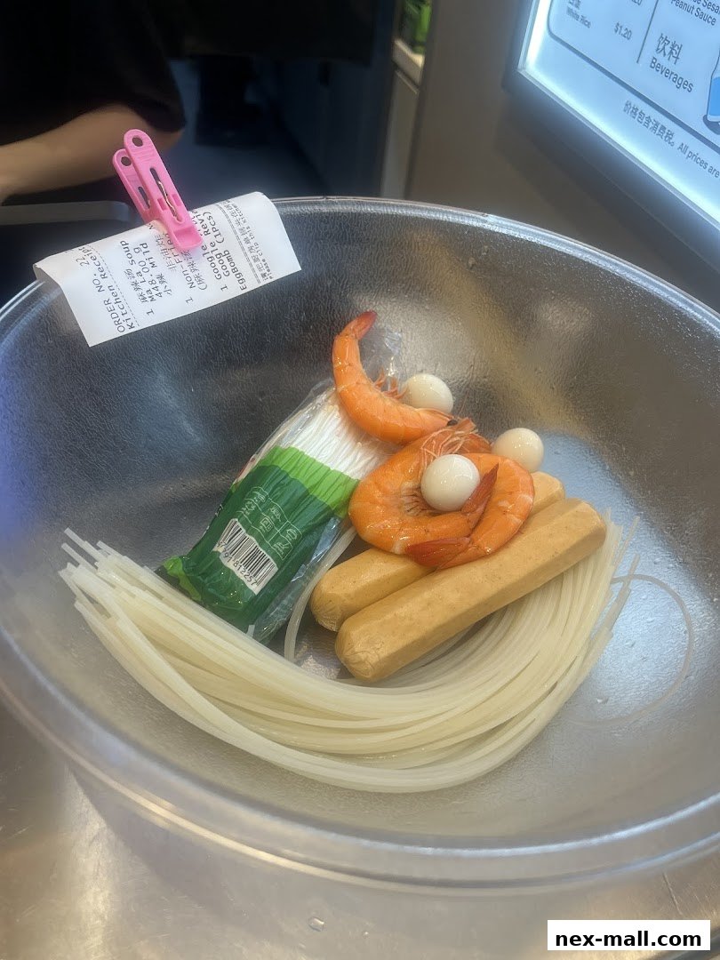 A bowl of ingredients for Mala Tang, including noodles, sausages, shrimp, and quail eggs, with a receipt.