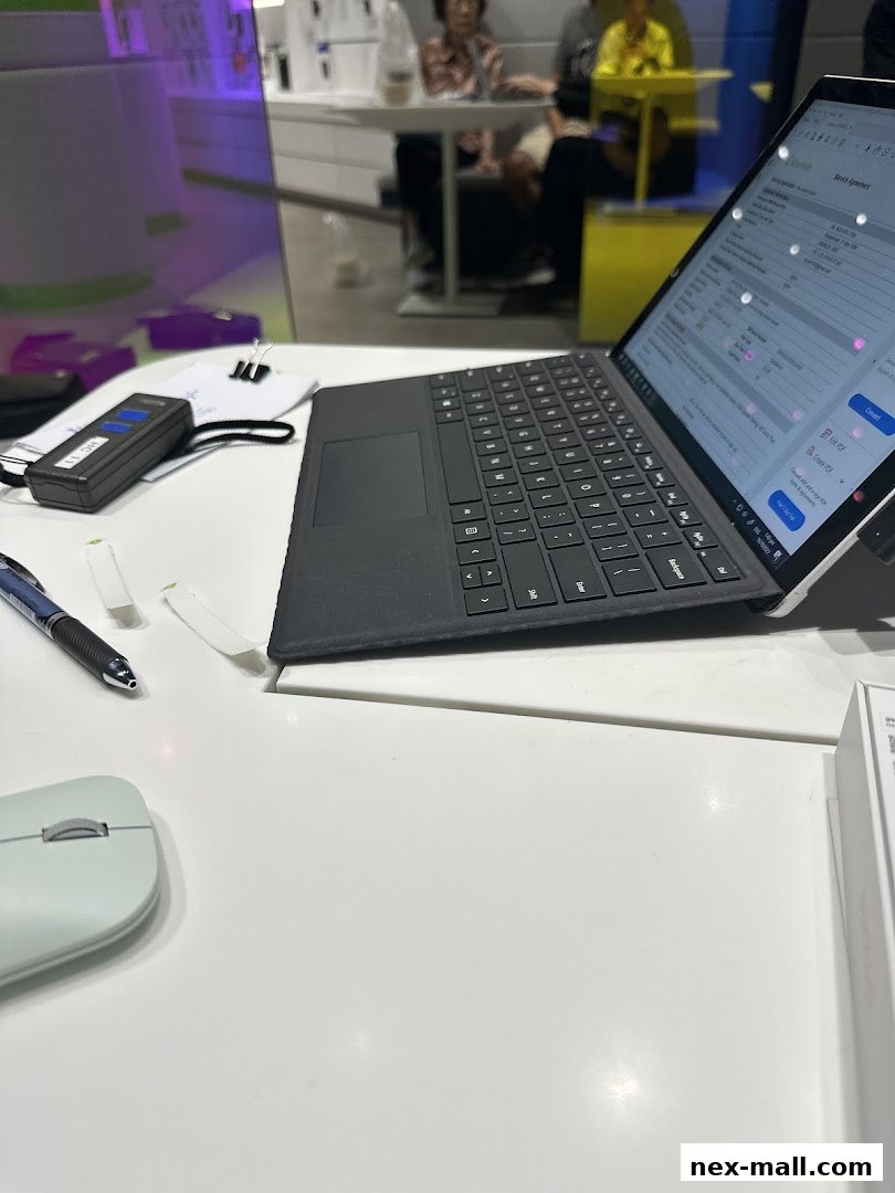 A close-up of a laptop with a service agreement on screen, next to a mouse and pen.