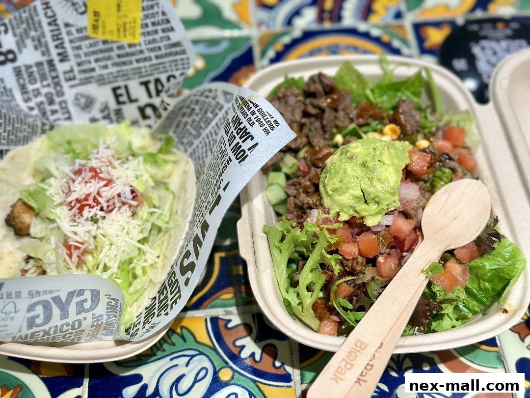 A taco and a salad bowl with guacamole, served on a colorful tiled surface.