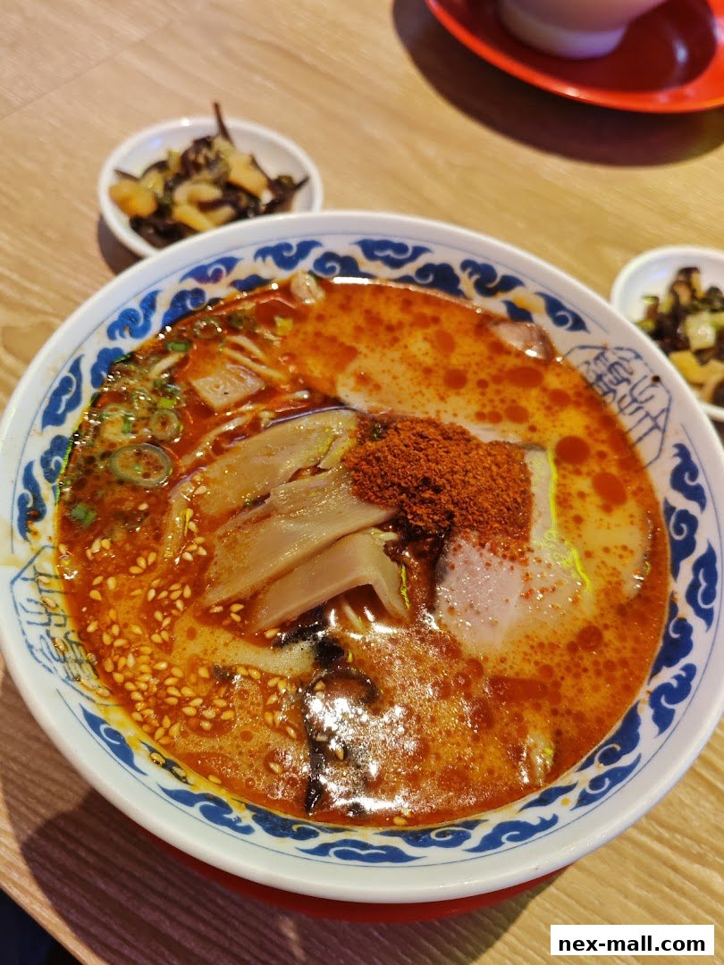 A close-up of a steaming bowl of ramen with rich broth, noodles, meat, and toppings.