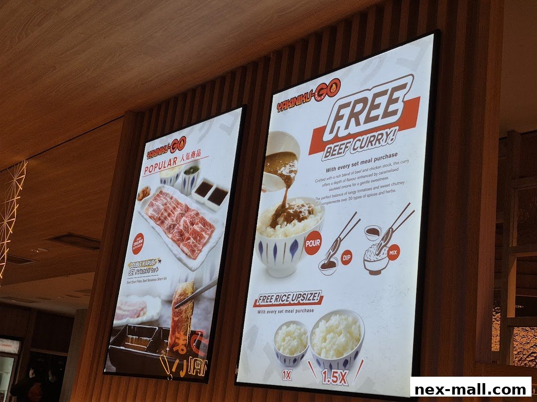 Two illuminated signs advertising Yakiniku-GO's popular dishes and a free beef curry offer.