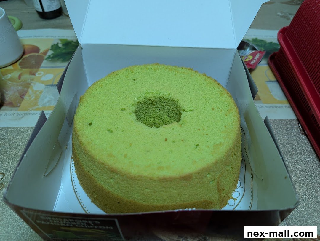 A light green pandan chiffon cake in its box, ready to be enjoyed.