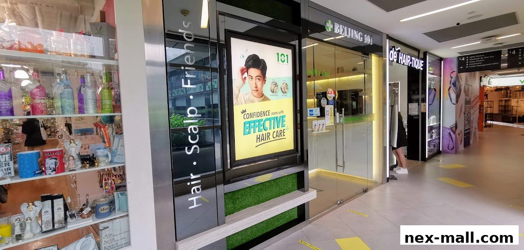 The exterior of Beijing 101 Hair Consultants Nex, featuring a glass entrance and promotional signage.