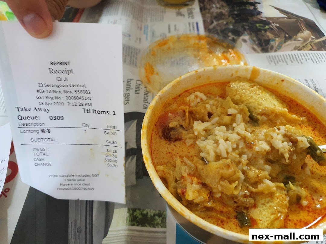 A close-up of a bowl of Lontong from Qi Ji, with a receipt visible.