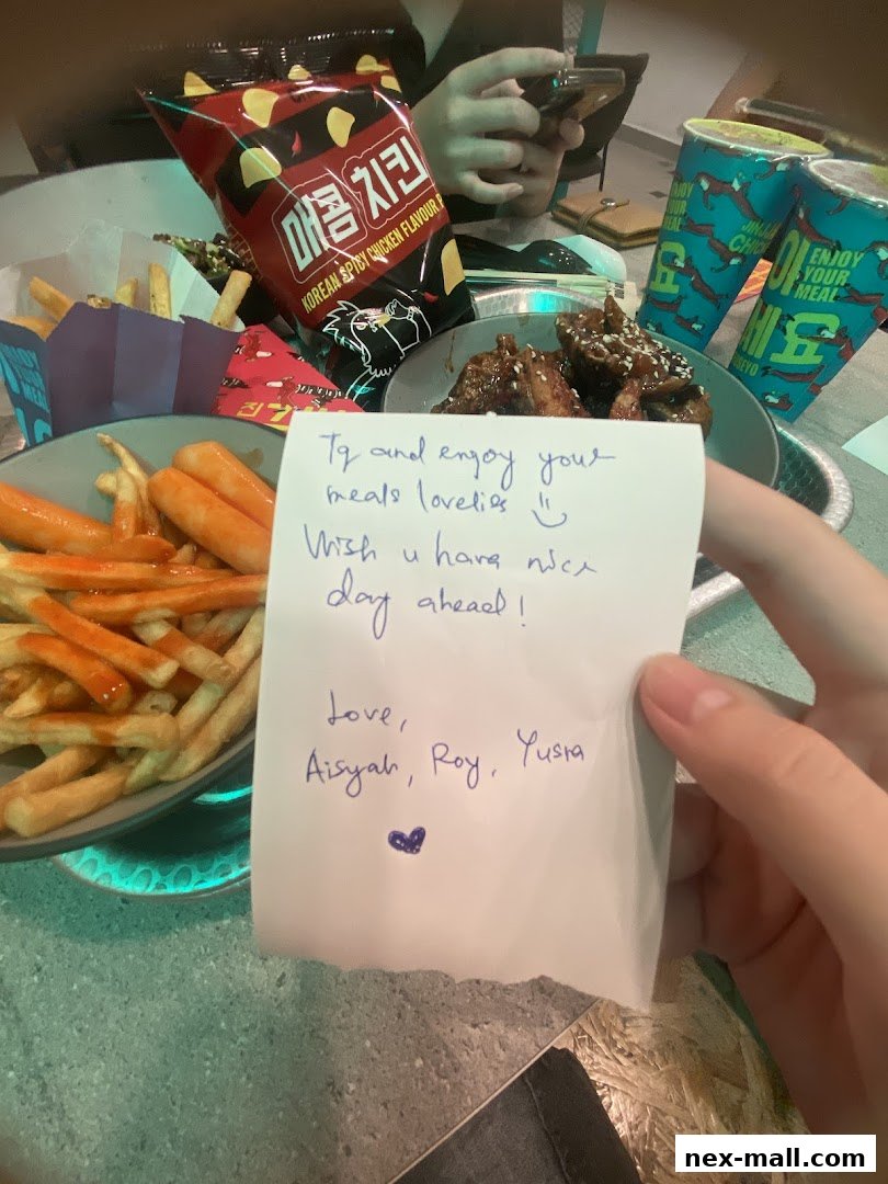 A table filled with Korean fried chicken, fries, and drinks, with a handwritten note.