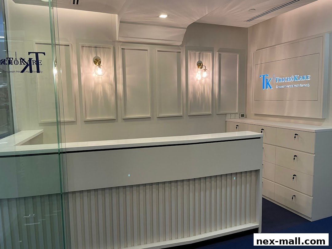 The reception area of TK TrichoKare, featuring a modern white counter and branded signage.