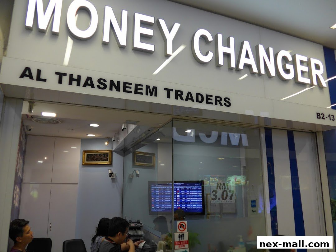 The exterior of AL Thasneem Traders Money Changer shop with prominent signage and a display screen.