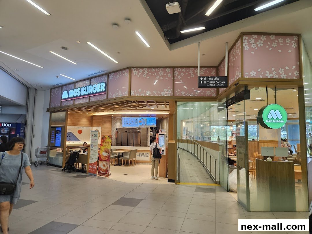 The exterior of a MOS Burger restaurant with its signature signage and cherry blossom decor.