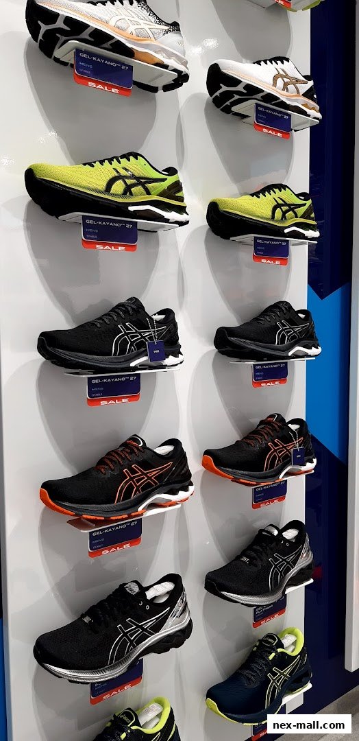 A display of various ASICS GEL-Kayano 27 running shoes in different colors on shelves.