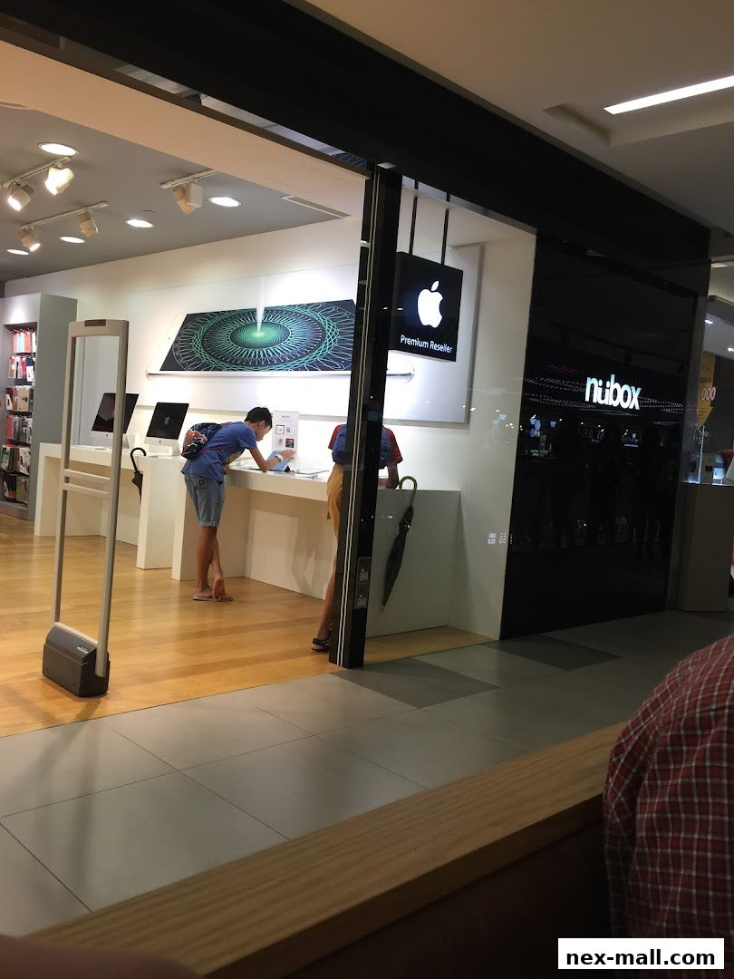 People browsing Apple products inside a modern tech store with a premium reseller sign.