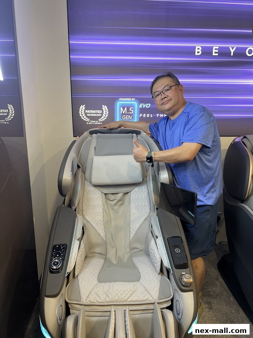 A man gives a thumbs up next to a high-tech massage chair.