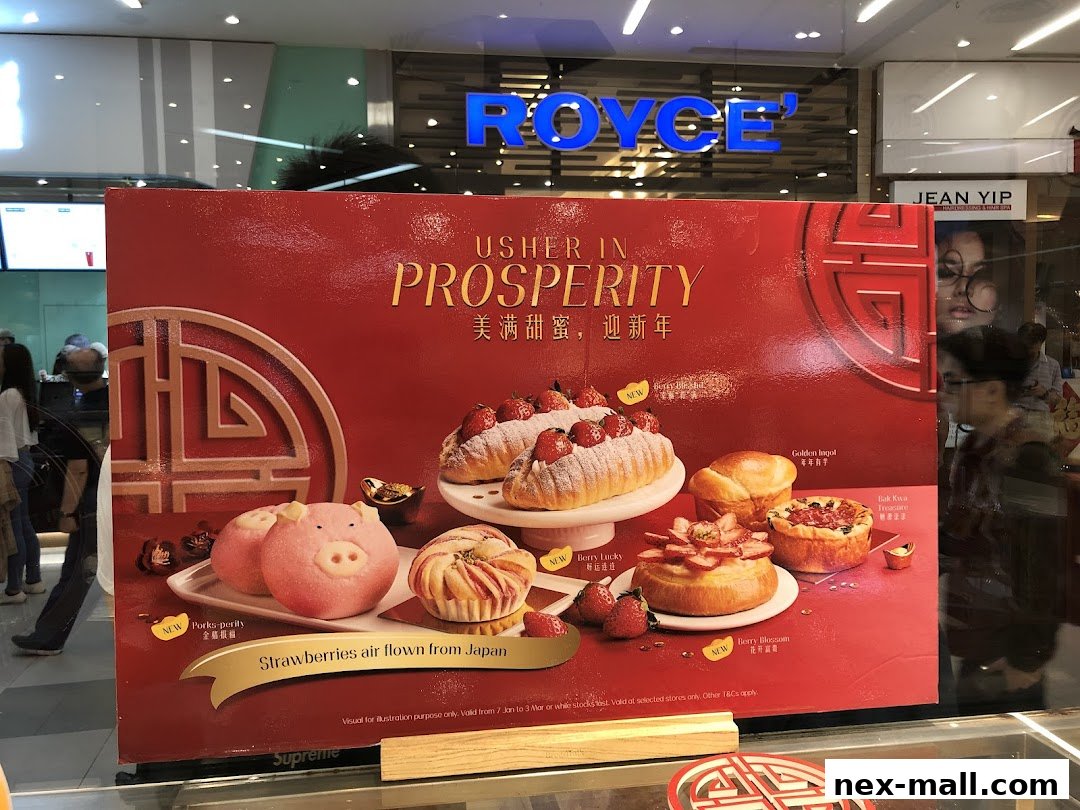 A festive display of pastries, including pig-shaped buns and strawberry-topped cakes, with Chinese New Year greetings.