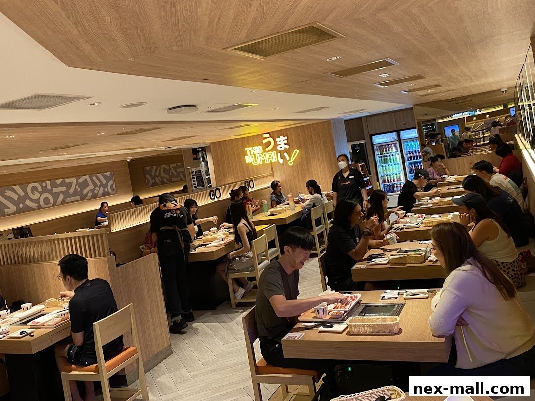 Diners enjoying a meal at tables in a brightly lit Japanese restaurant.