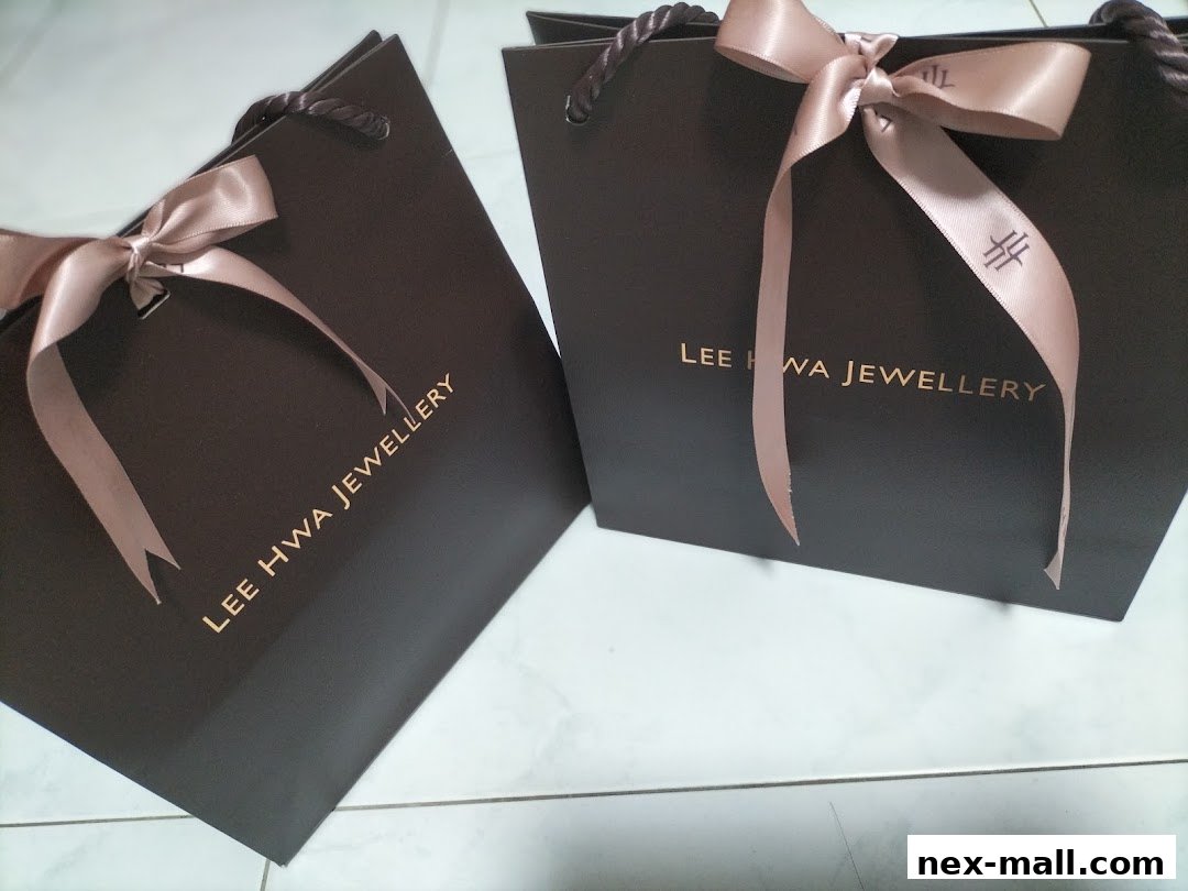 Two dark brown shopping bags with pink ribbons from Lee Hwa Jewellery.