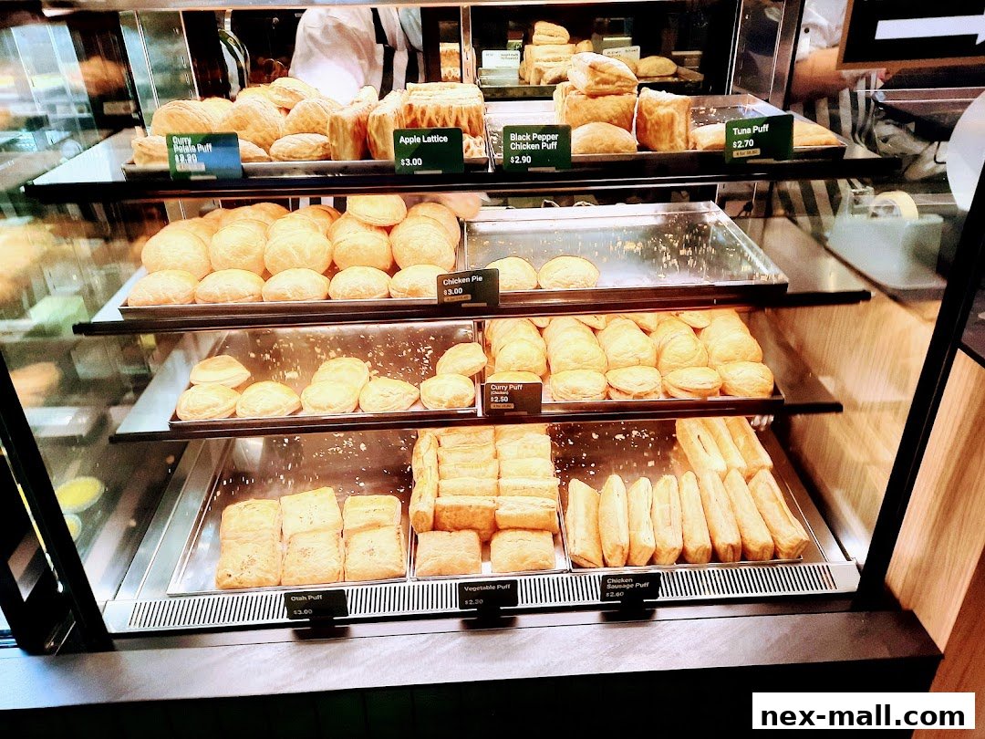 A display case filled with various freshly baked pastries and savory puffs.