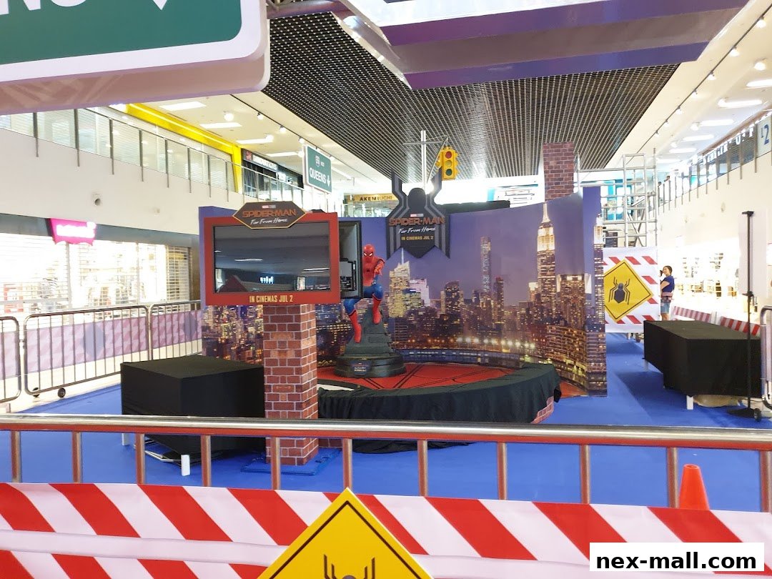 A Spider-Man promotional display with a cityscape backdrop and a character statue.