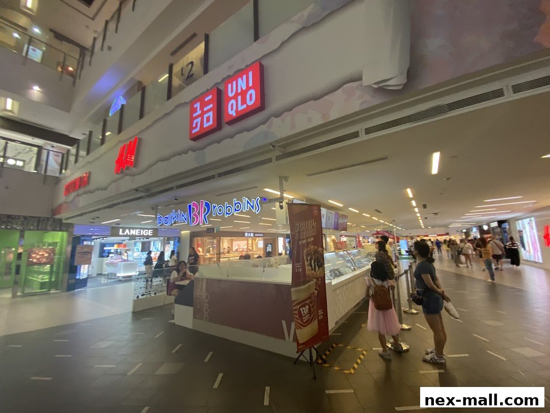 A shopping mall corridor with various stores including UNIQLO, H&M, Laneige, and Baskin Robbins.