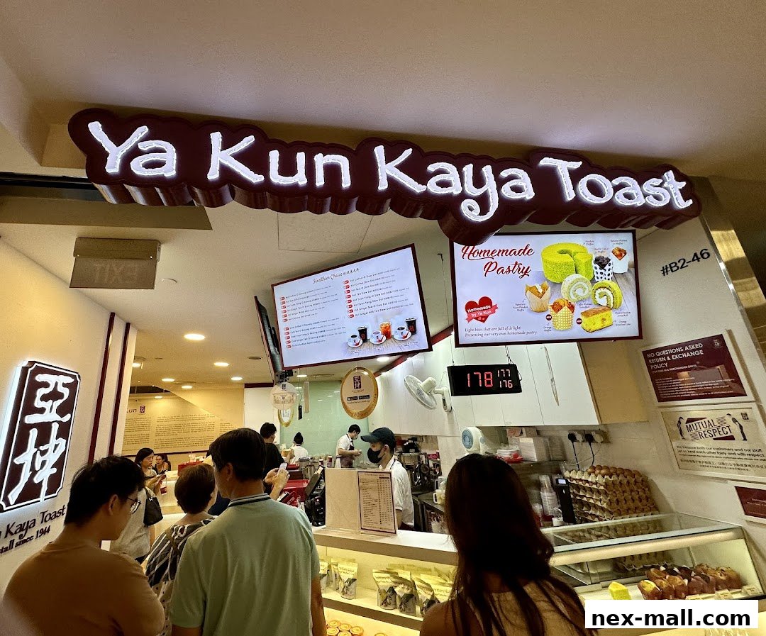 Customers queue at Ya Kun Kaya Toast, with a menu and pastry display visible.