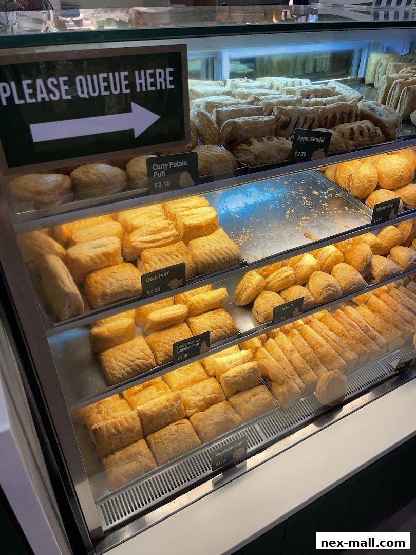 A display case filled with various freshly baked pastries and puffs at Polar Puffs & Cakes.