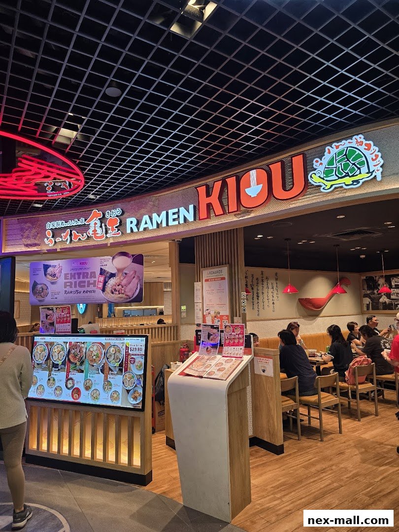 The exterior of Ramen Kiou, a Japanese restaurant, with a digital menu and seating area visible.