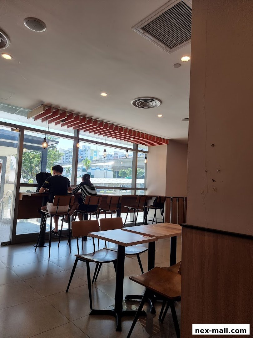 Interior view of a Burger King with customers seated at tables and a counter.