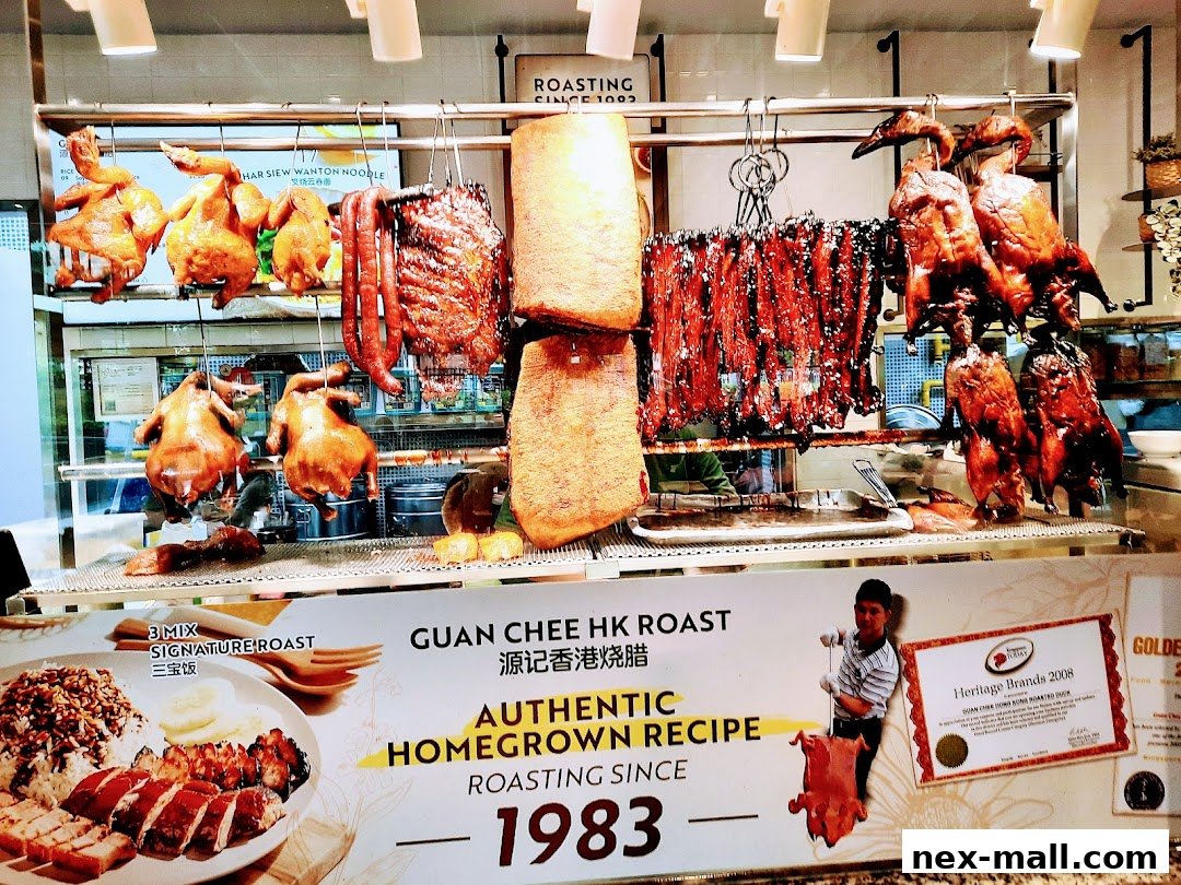 A display of various roasted meats including chickens, ducks, and char siu, with a promotional sign.
