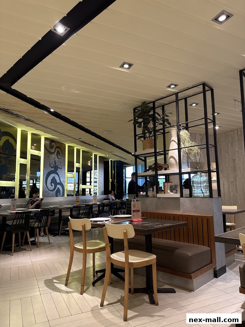 Interior view of a modern restaurant with tables, chairs, and decorative elements.