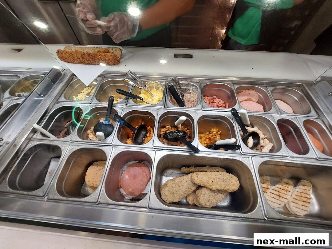 A Subway sandwich bar with various fillings and a sandwich being prepared.