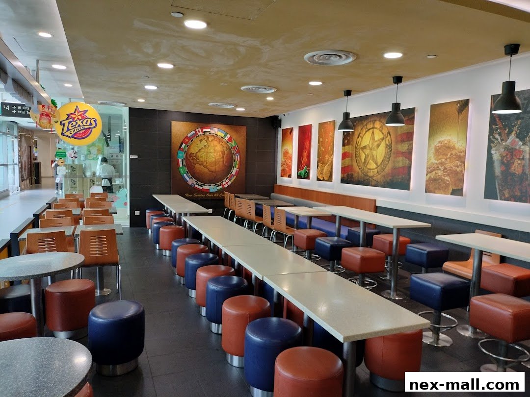 Interior of Texas Chicken NEX with seating, tables, and wall art.