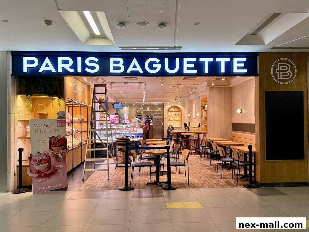 The exterior of Paris Baguette NEX, showcasing its inviting interior and display of baked goods.
