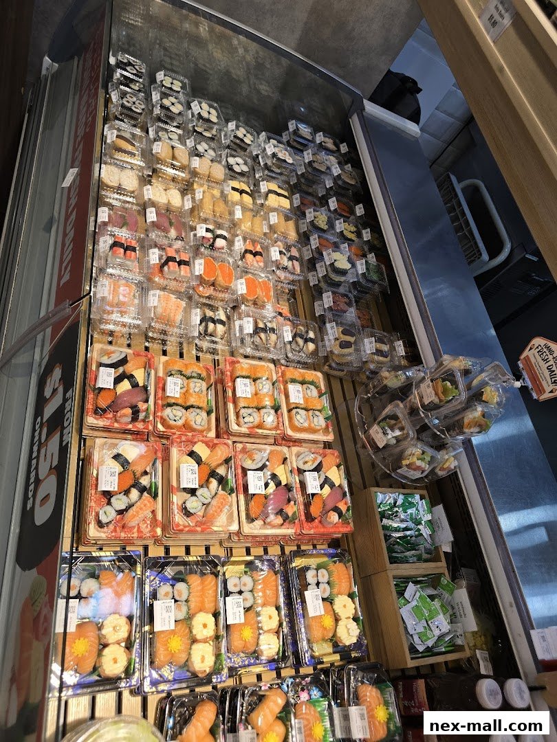 A display of pre-packaged sushi and sashimi sets in clear plastic containers.