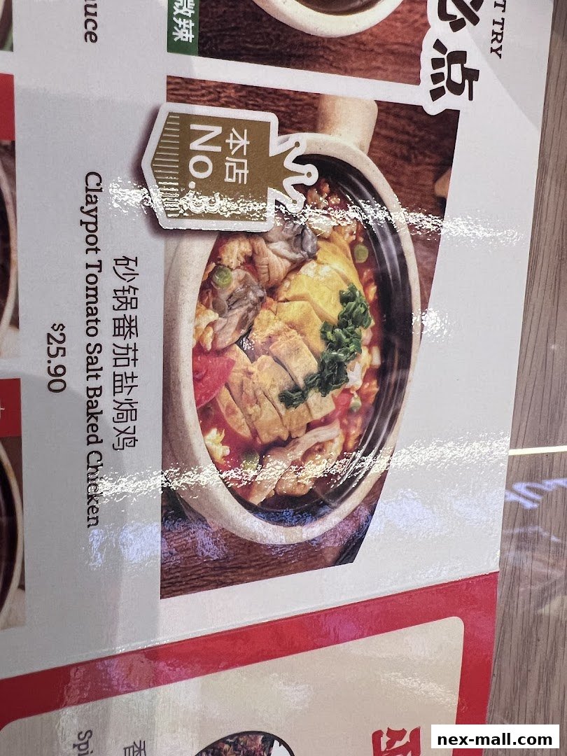 A close-up of a menu item featuring claypot tomato salt baked chicken.