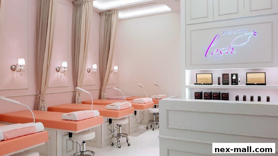 Interior of a beauty salon with multiple lash extension beds and products displayed.